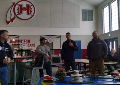 Volunteer Linemen stand in front of the class to present
