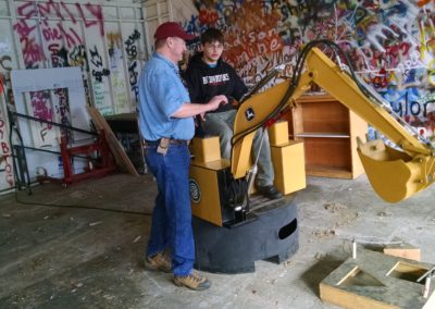 Instructor showing a student how to operate machinery