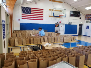 School gym, lunch brown bags, distribution