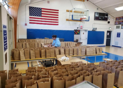 School gym, lunch brown bags, distribution