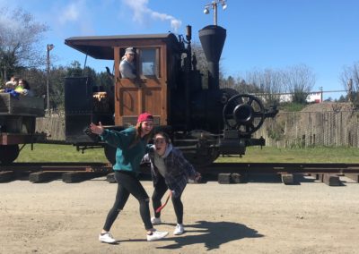 Two female students pose in front of a train engine