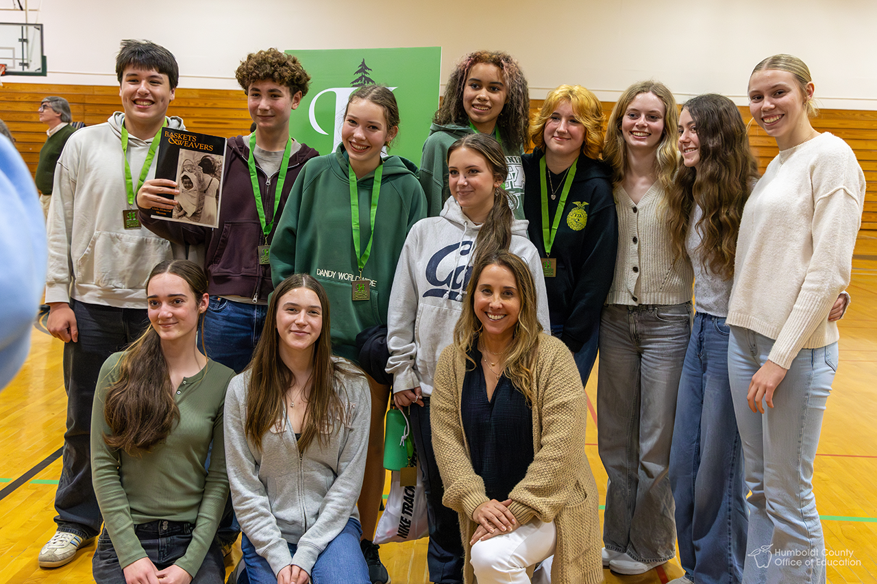 A group of History Day champions pose for photos with their awards.