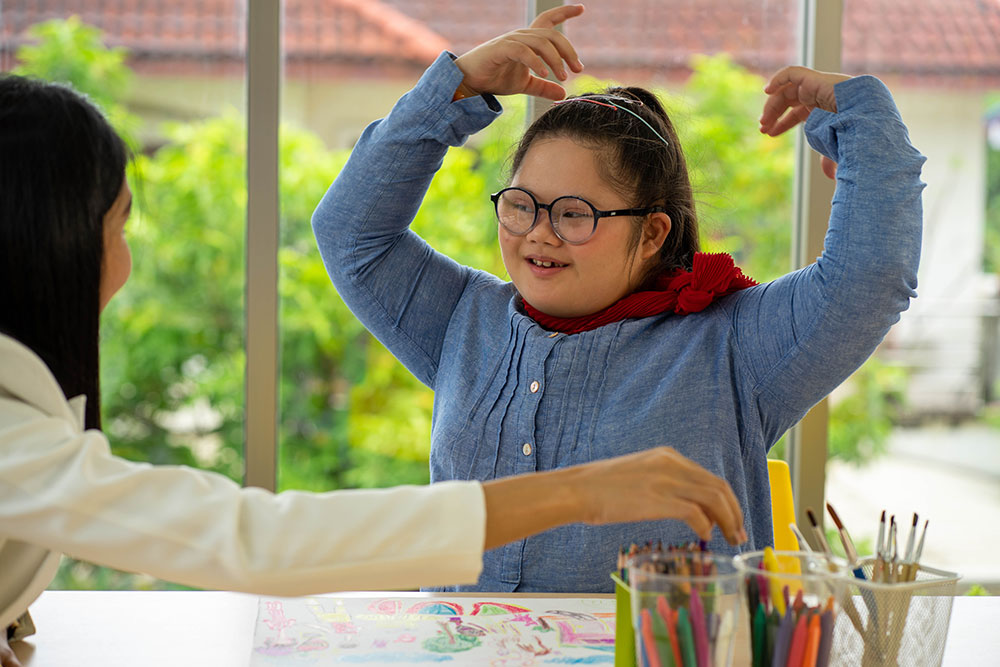 A child with downs syndrome interacting with a teacher