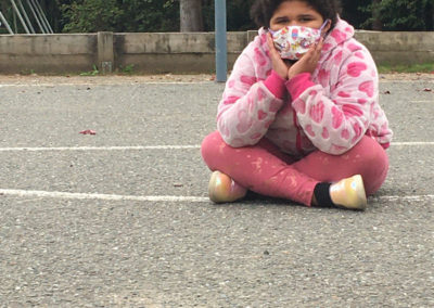 Photo of a lonely student on a playground with a mask on