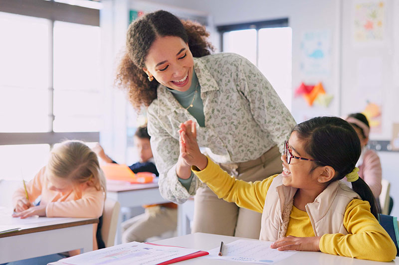A teacher high-fiving a student