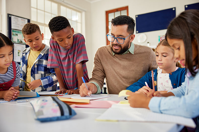 A teacher talking to a group of students in a classroom