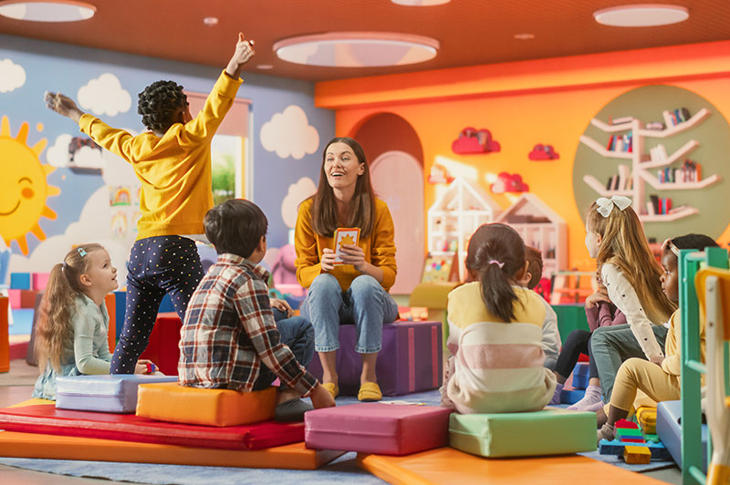 A kindergarten teacher in a classroom with students
